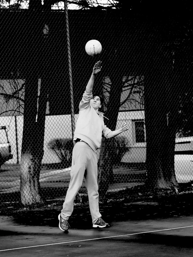 A volleyball player reaching up to serve